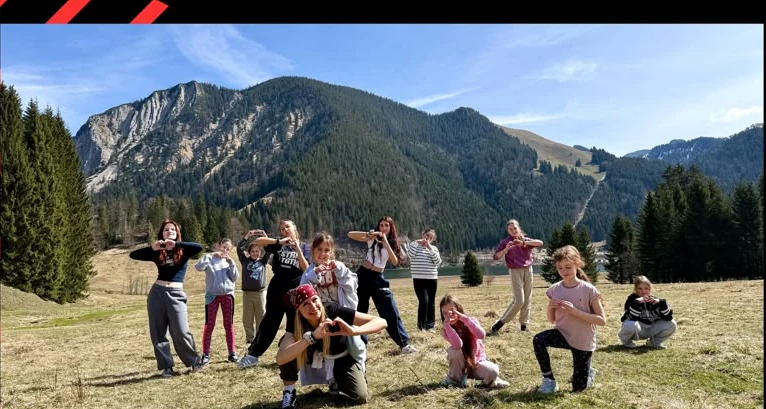 Kinder tanzen gemeinsam im Freien in einer Berglandschaft